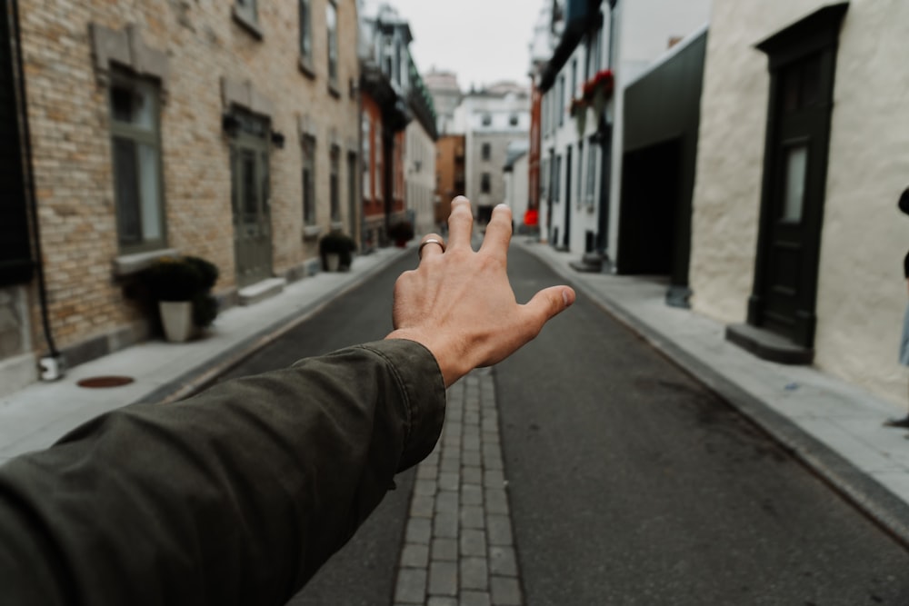 person in black jacket raising right hand