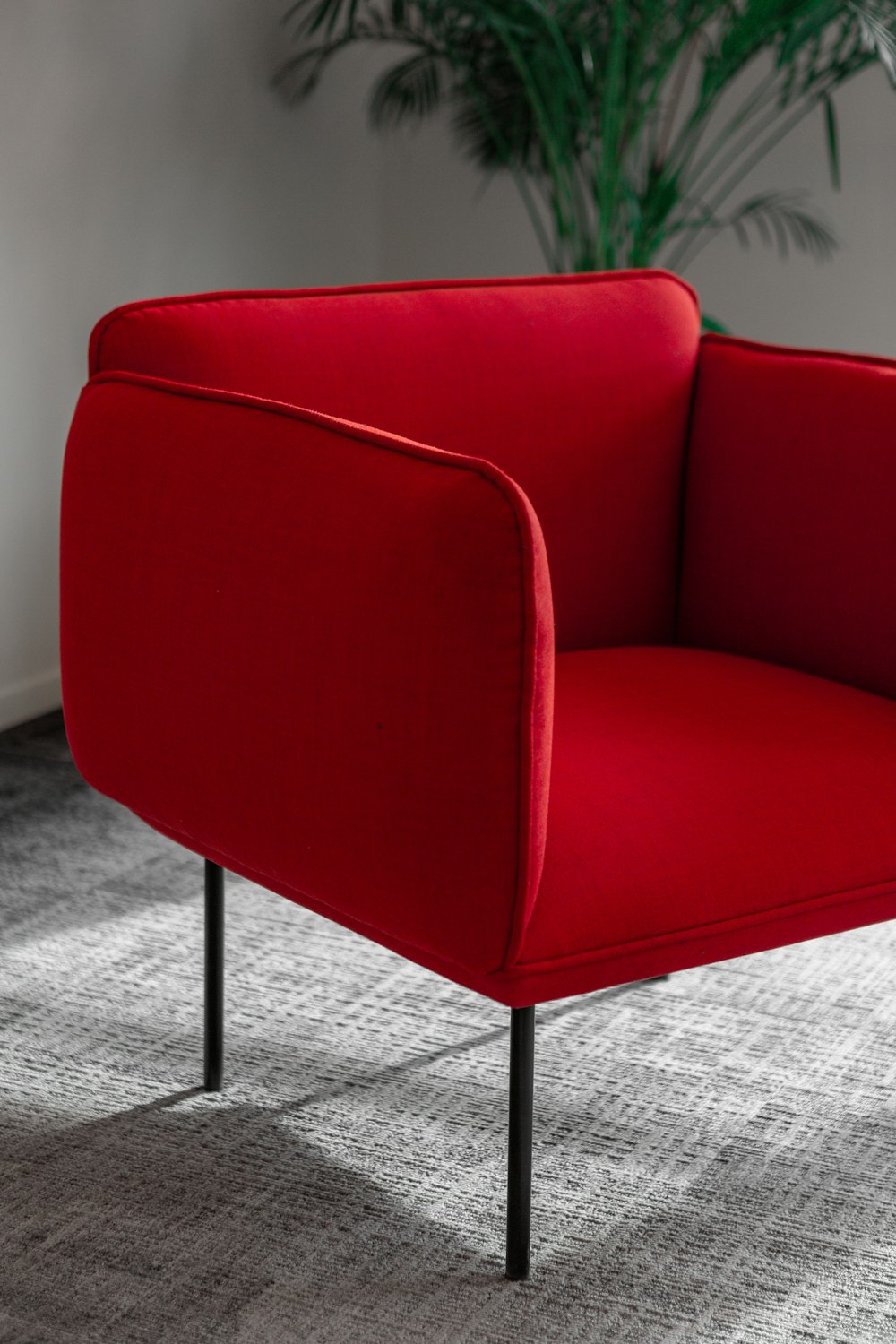 a red chair sitting on top of a carpeted floor