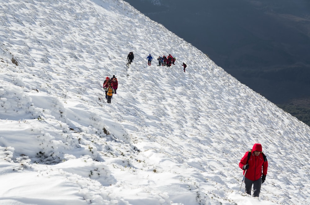 people hiking on snow covered mountain during daytime