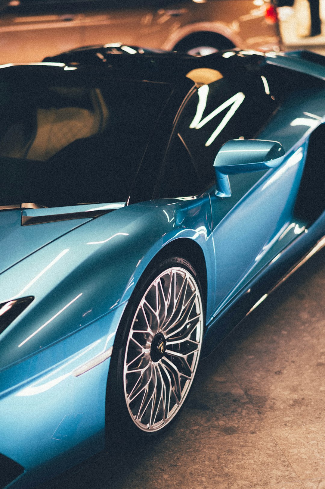 blue lamborghini aventador parked on gray pavement