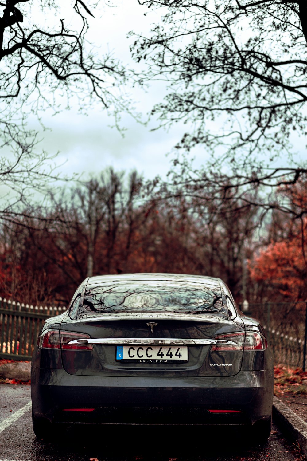 black mercedes benz c class parked near brown wooden fence during daytime