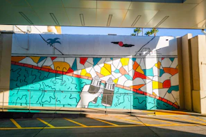 A colorful mural showcasing Islamic geometric patterns intertwined with vibrant Caribbean flora.
