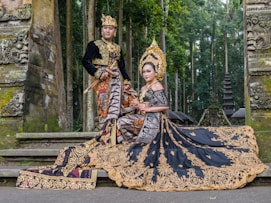 woman in black and gold dress sitting on concrete bench