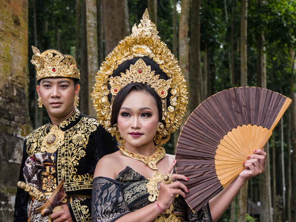 woman in black and gold floral dress holding umbrella