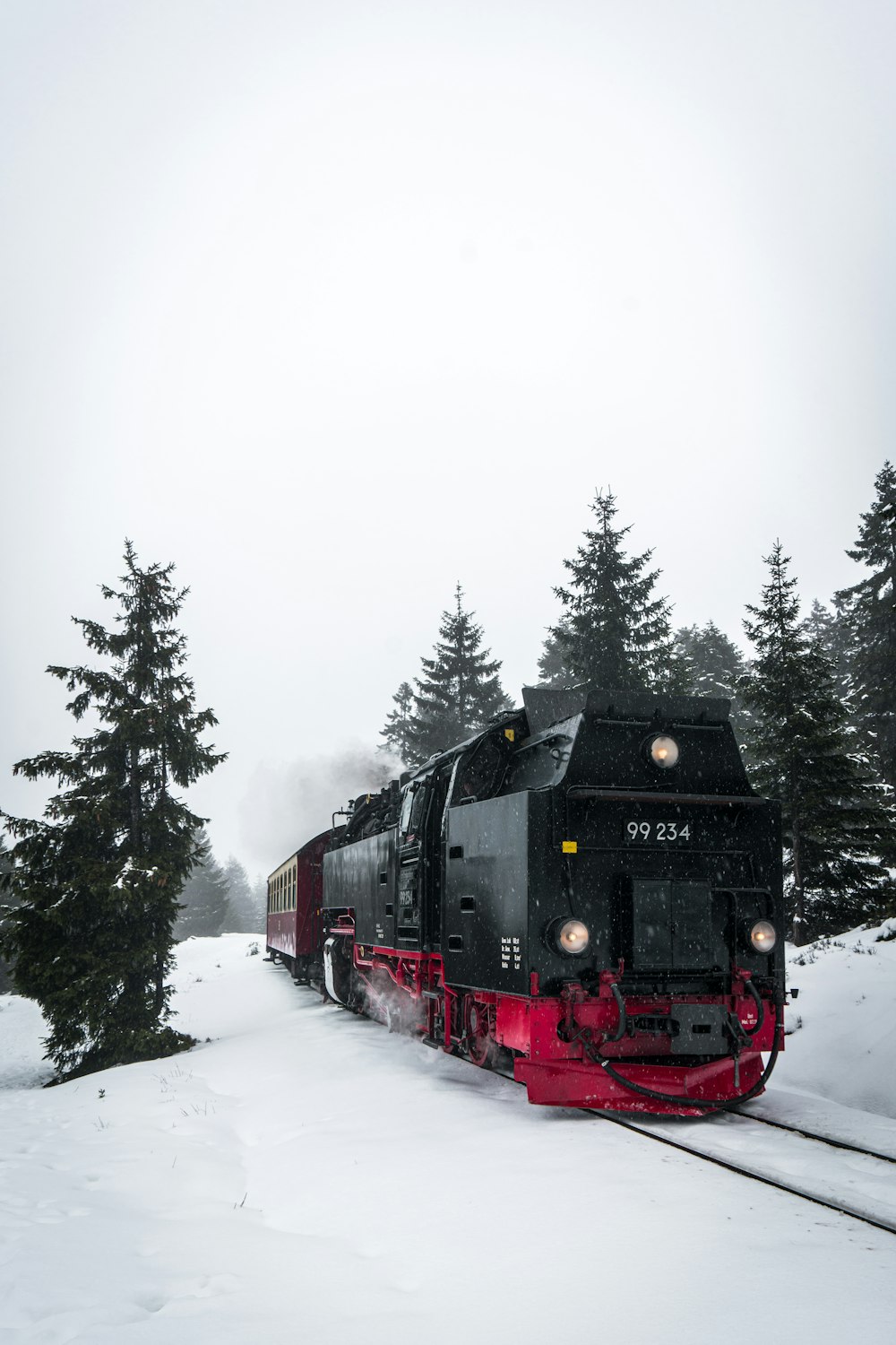 red and black train on snow covered ground during daytime
