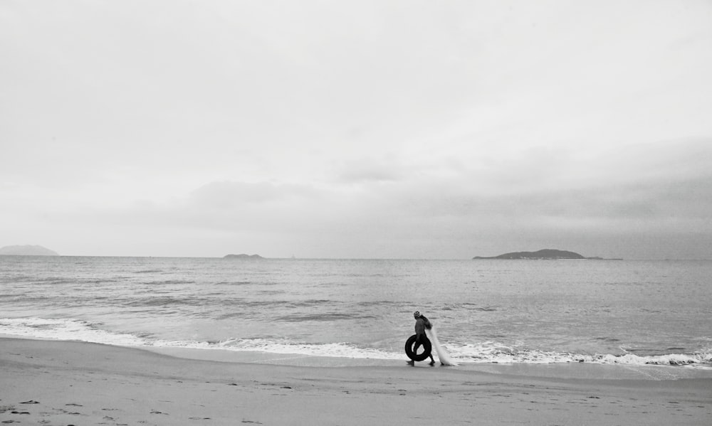 grayscale photo of man and woman sitting on beach