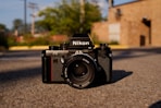 black and silver nikon dslr camera on gray concrete floor