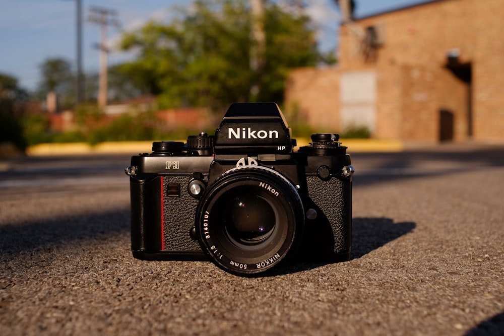 Appareil photo reflex numérique Nikon noir et argent sur sol en béton gris