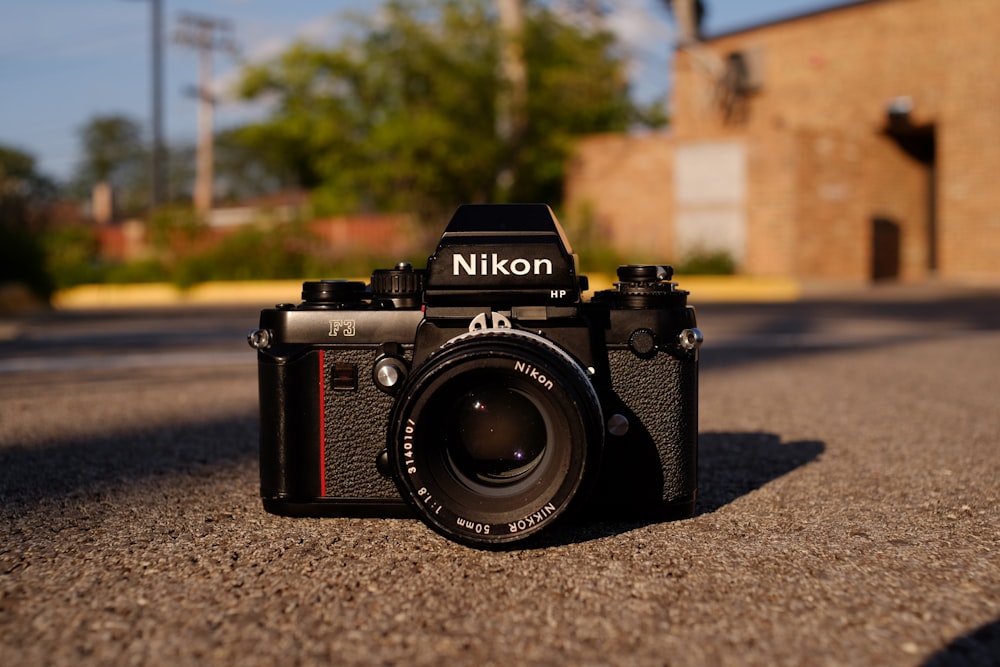 black and silver nikon dslr camera on gray concrete floor