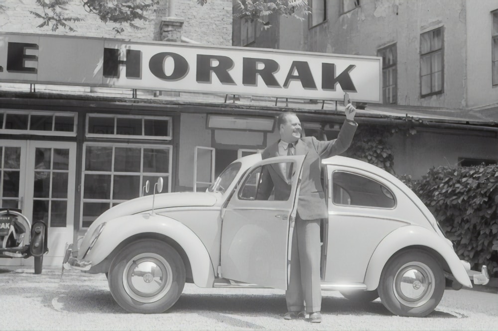 woman in white tank top and white pants standing beside white vintage car during daytime