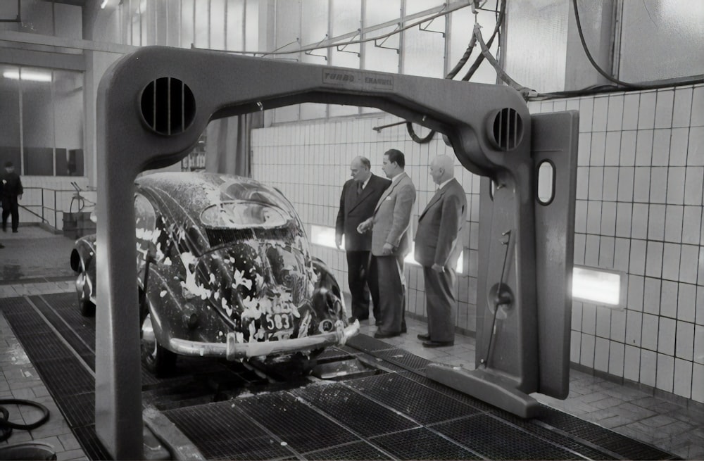 man in black jacket standing beside black car