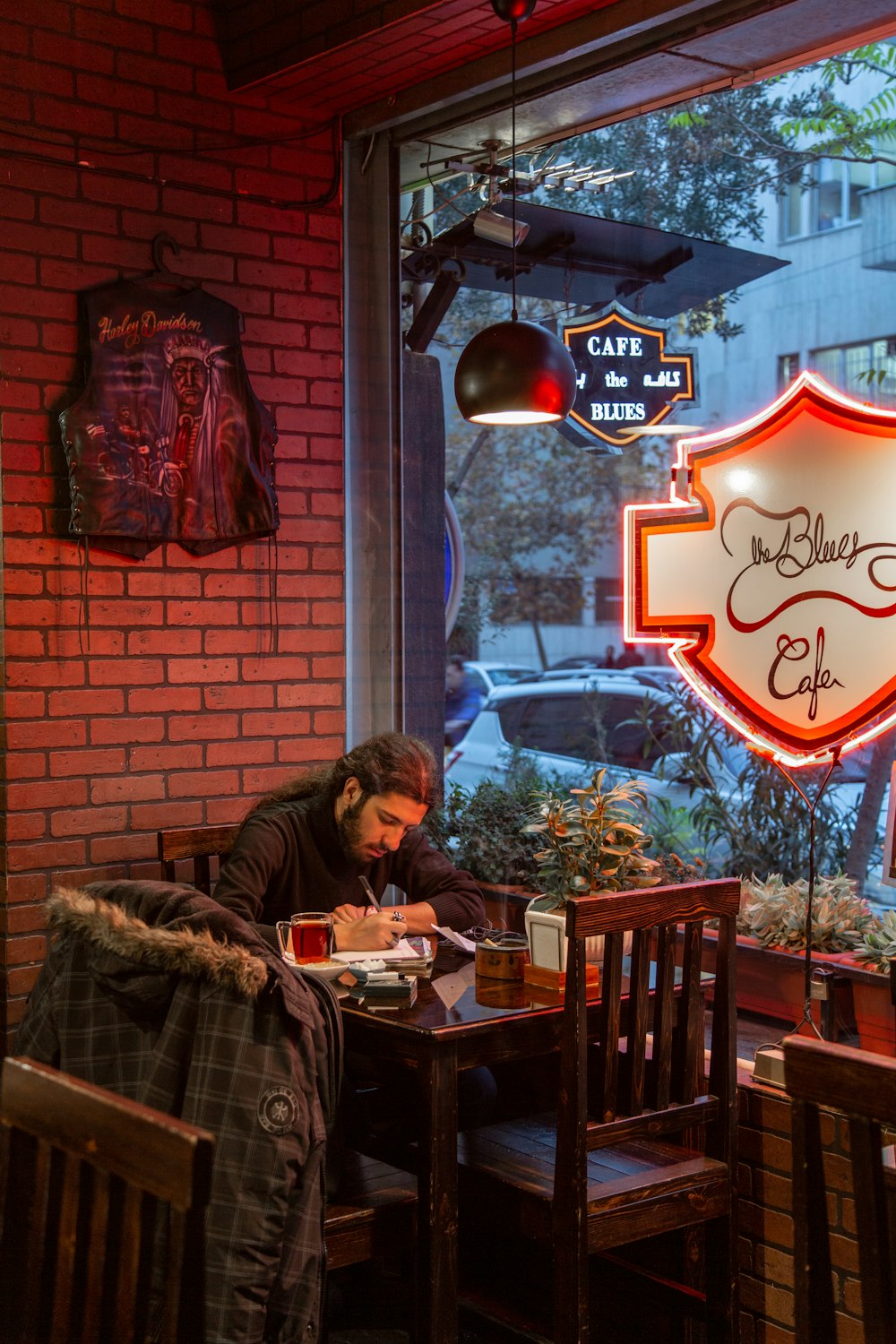 man in brown jacket sitting on chair