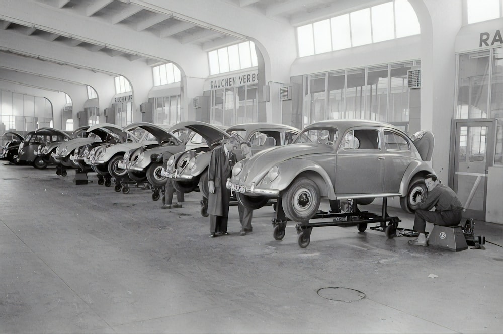 Foto en escala de grises de coches antiguos aparcados frente al edificio
