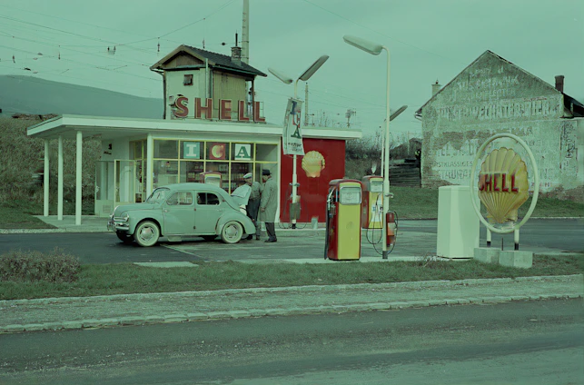 A friendly gas station attendant helping a customer at a modern service station.