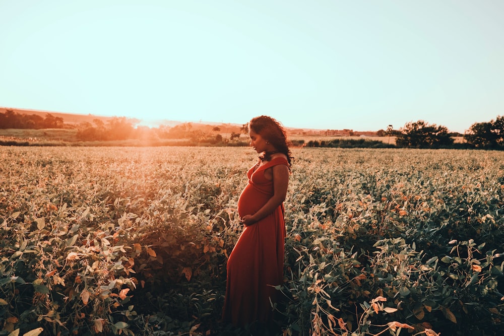 woman in orange dress standing on brown dried leaves during daytime