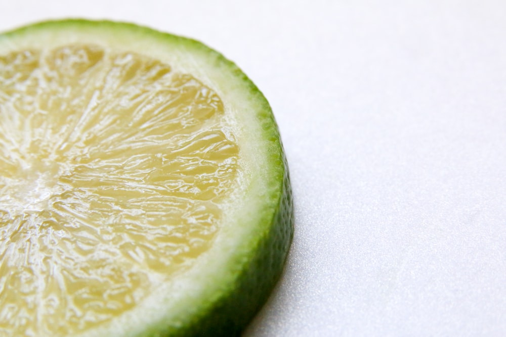 a slice of lime sitting on top of a white table