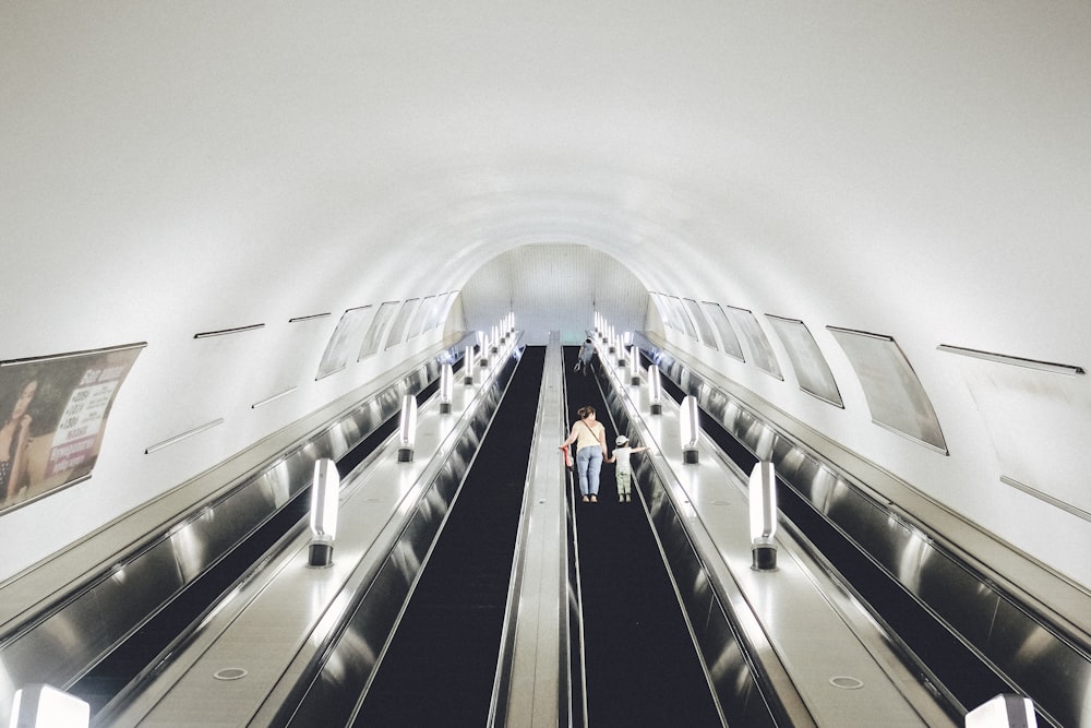 Menschen, die auf weißen und schwarzen Rolltreppen gehen