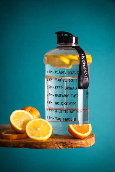 Water bottle with time markers full of water and cut up oranges