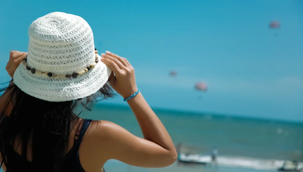 woman in black tank top wearing white sun hat