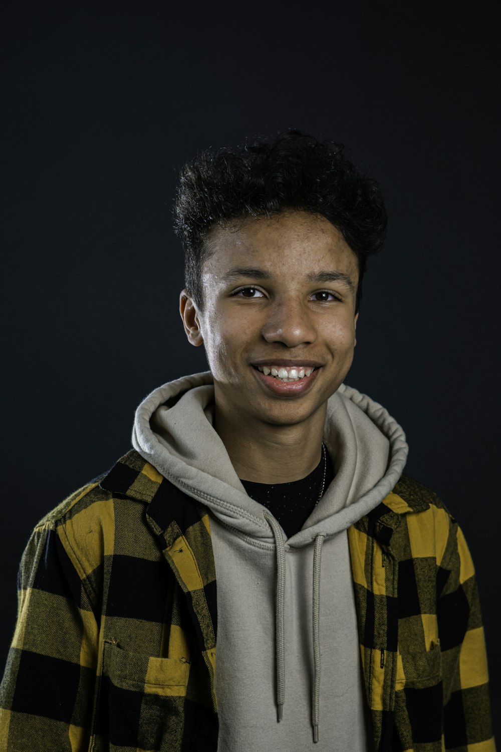 man in yellow and black zip up hoodie smiling