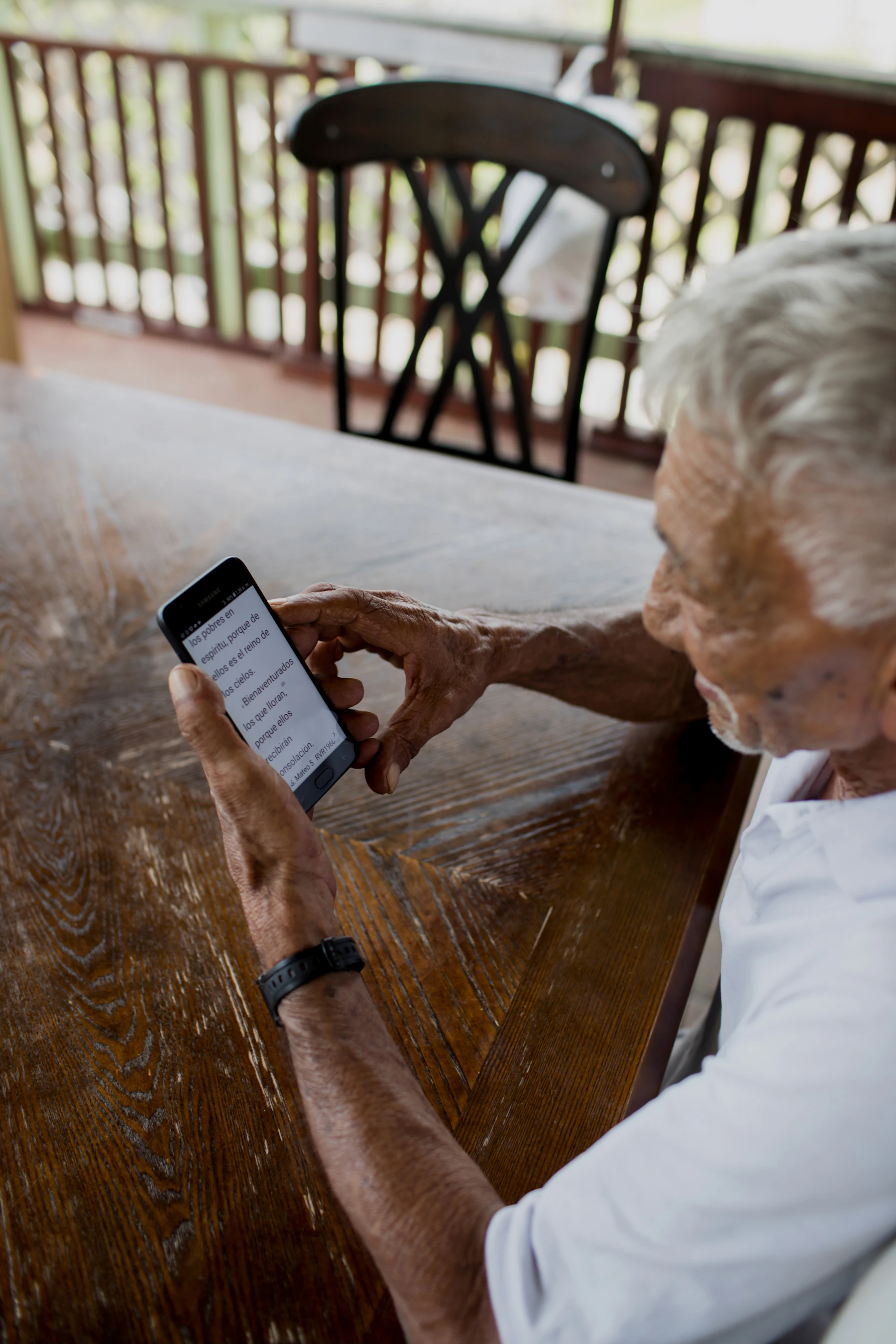 An older man reads a text message on his phone