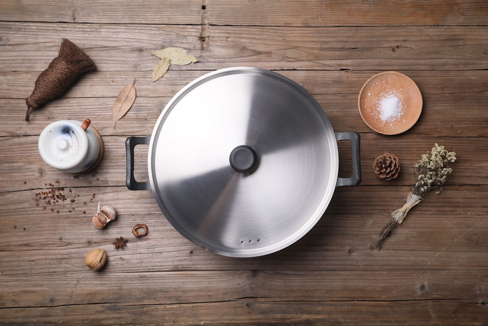 stainless steel cooking pot beside brown round fruit on brown wooden table