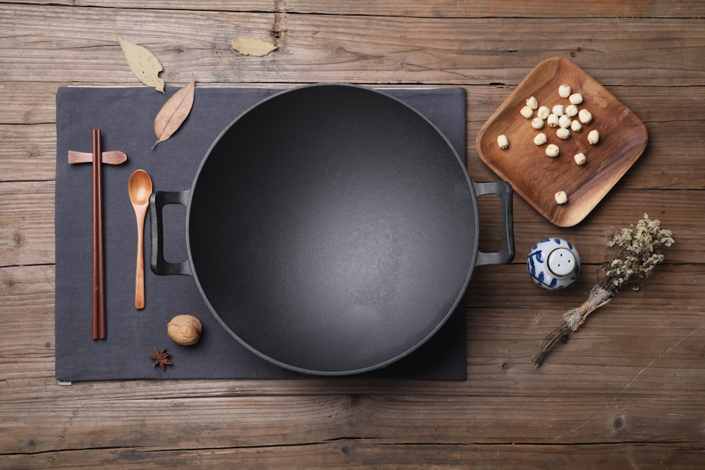 assiette ronde noire à côté de ciseaux en bois brun