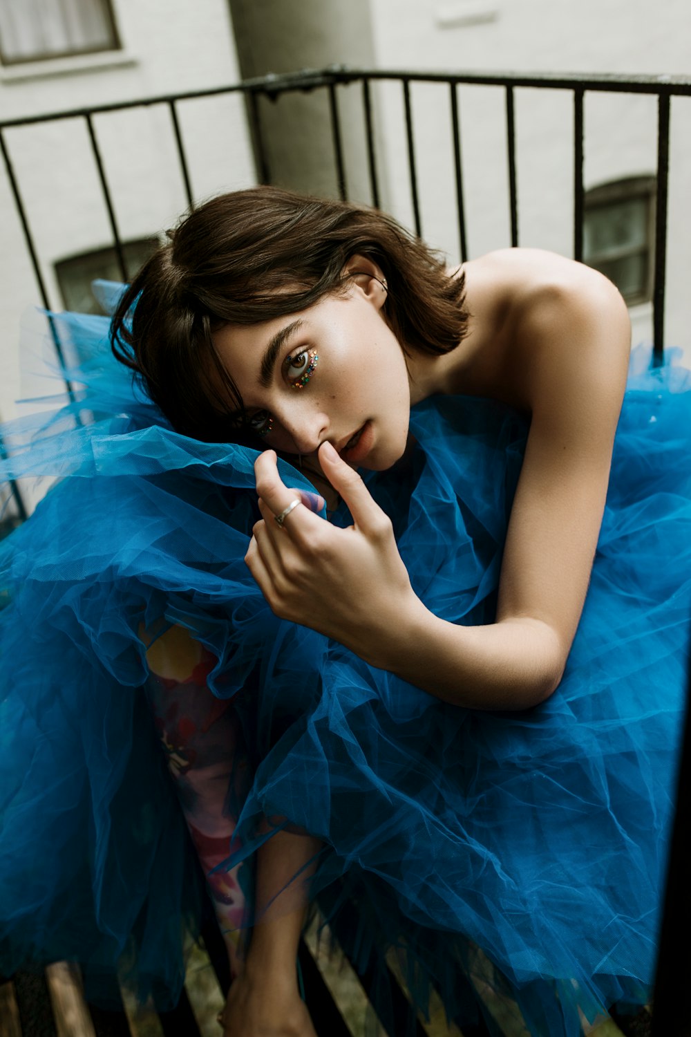 Femme en robe tube bleue allongée sur textile bleu