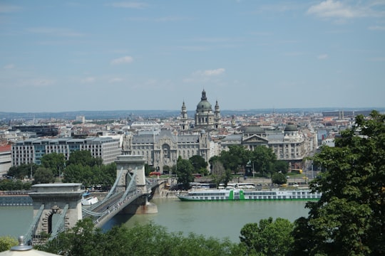 white bridge over river near city buildings during daytime in Széchenyi Chain Bridge Hungary