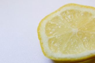 Close-up of a fresh lemon half with droplets of water, highlighting its natural texture.