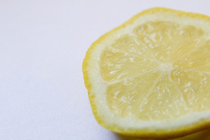 Close-up of a fresh lemon half with droplets of water, highlighting its natural texture.