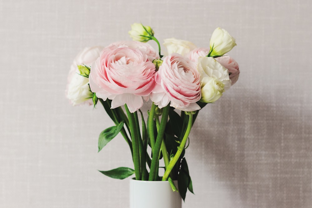 pink and white roses in white ceramic vase