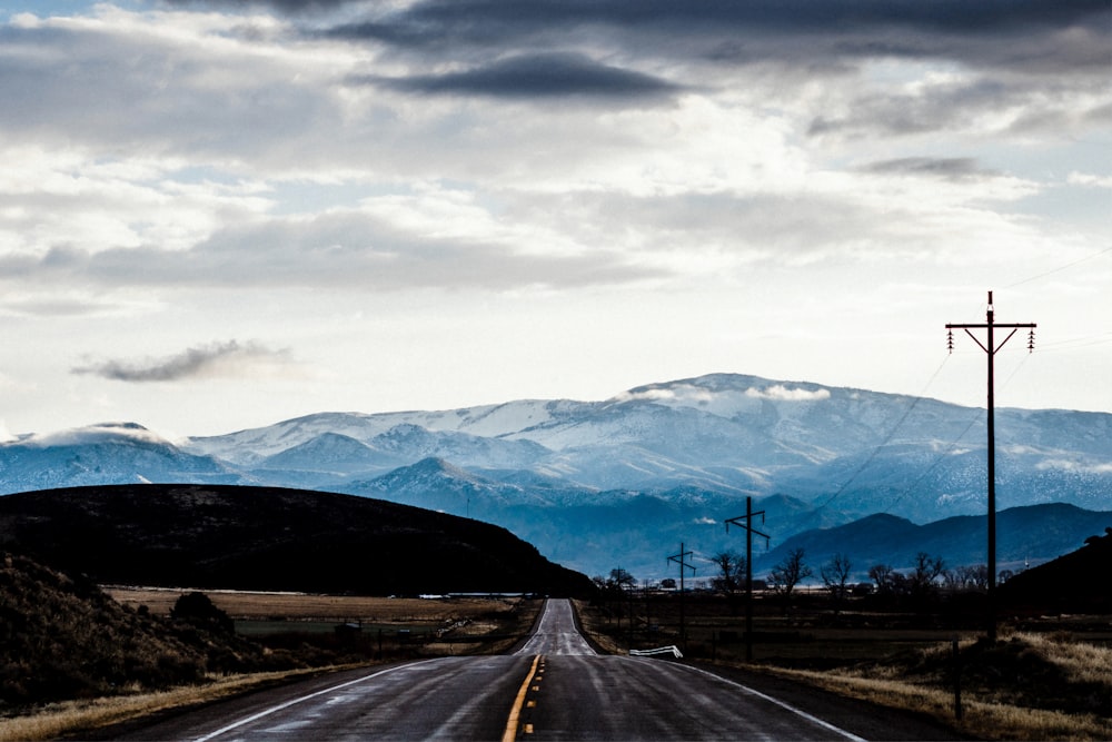 black asphalt road near mountains during daytime