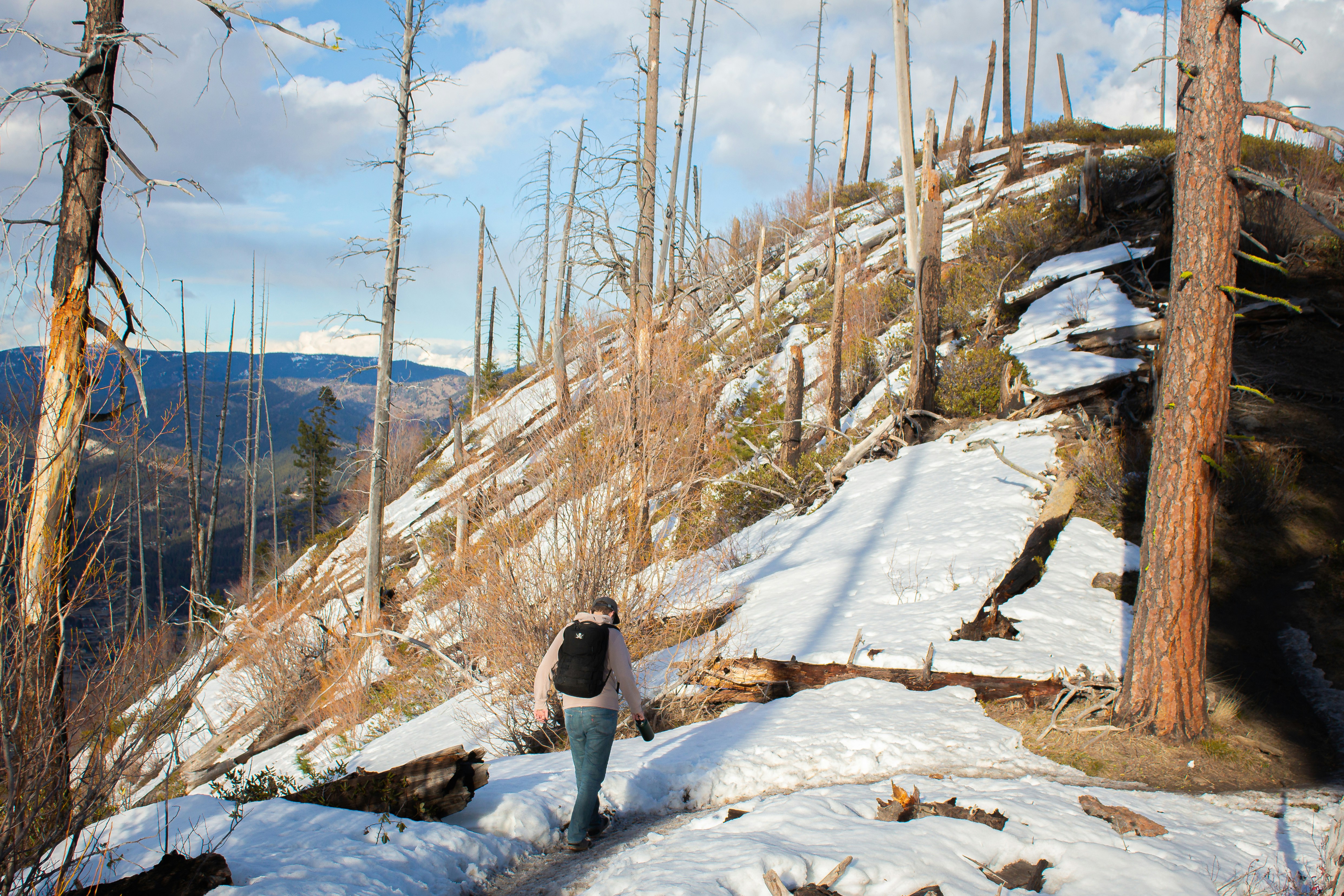 person in black jacket and gray pants standing on snow covered ground during daytime