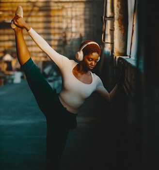 a woman in a white shirt and headphones doing a dance pose