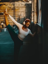 a woman in a white shirt and headphones doing a dance pose