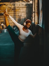 a woman in a white shirt and headphones doing a dance pose