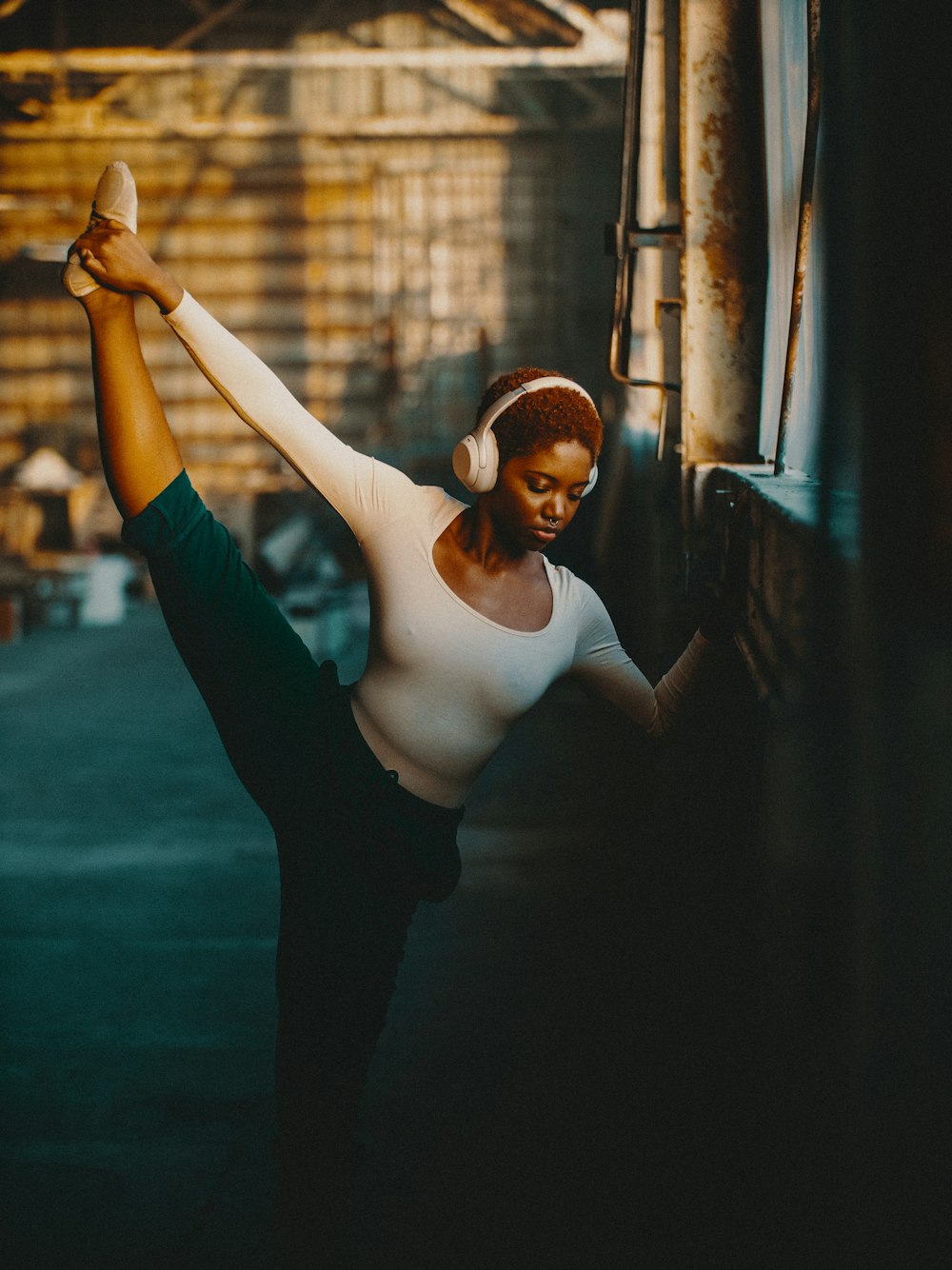 uma mulher em uma camisa branca e fones de ouvido fazendo uma pose de dança