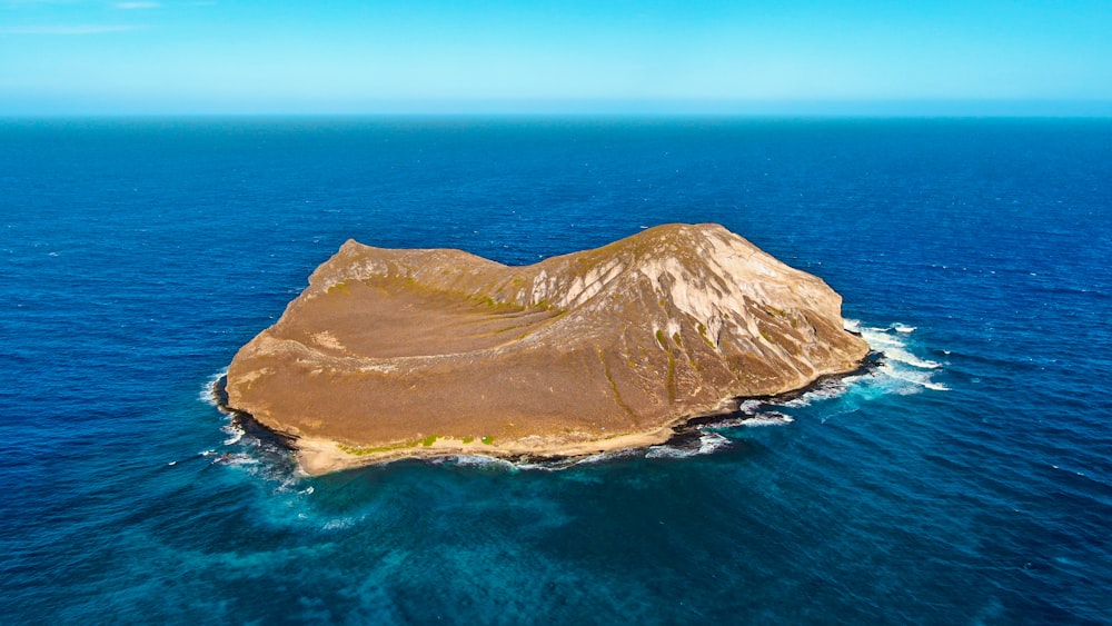 brown mountain beside blue sea during daytime