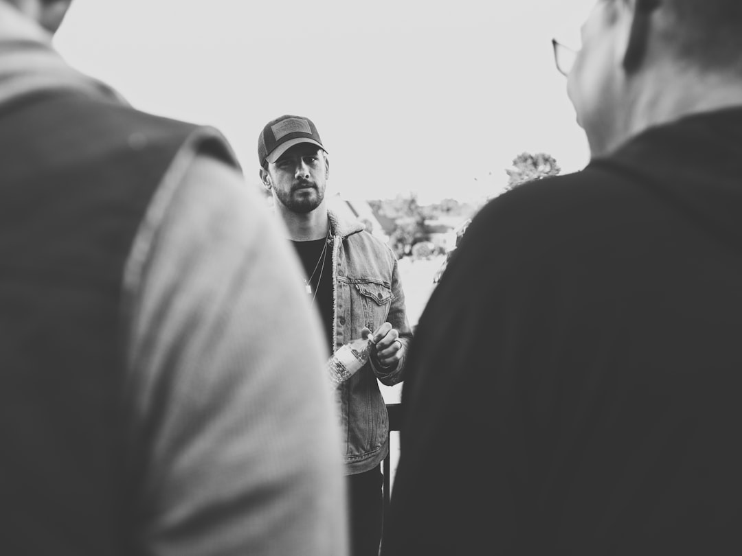 grayscale photo of man and woman standing near each other