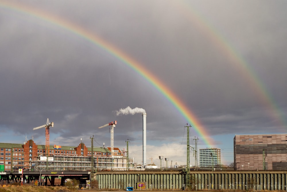 white and brown ship on dock under rainbow