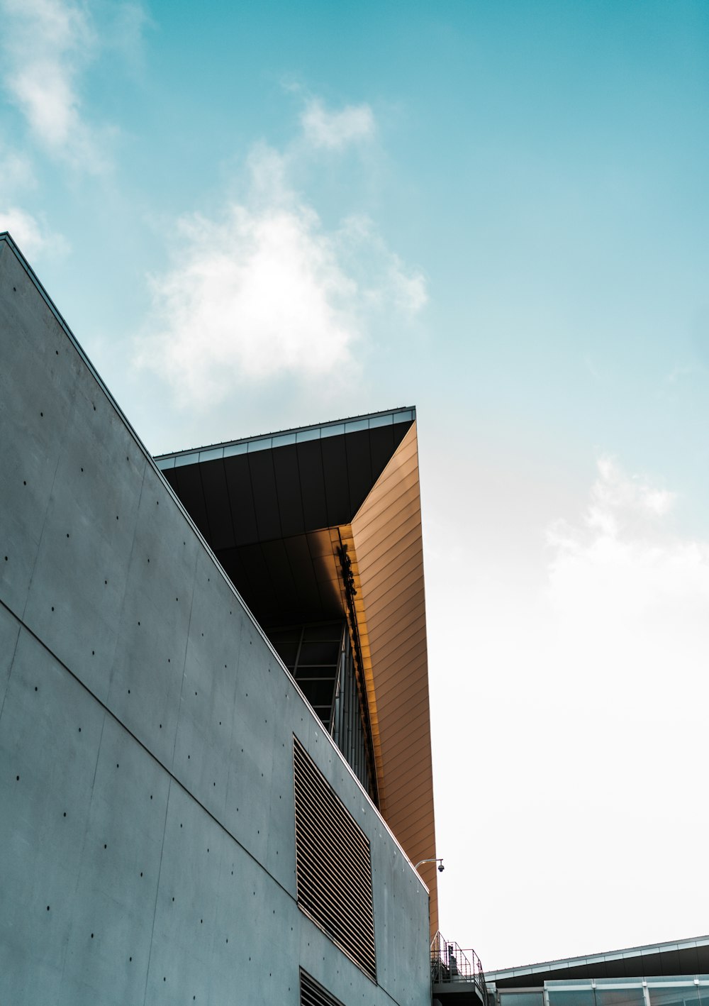 white concrete building under white clouds during daytime