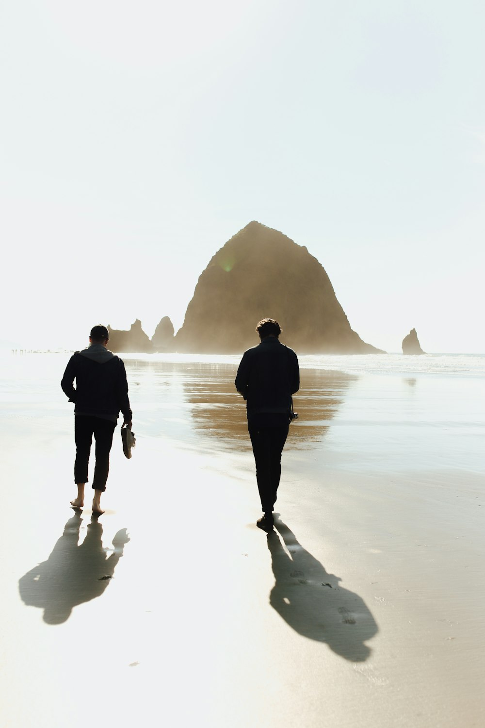 man and woman walking on beach during daytime