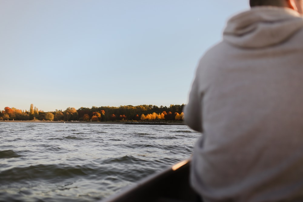 person in white hoodie sitting on boat during daytime