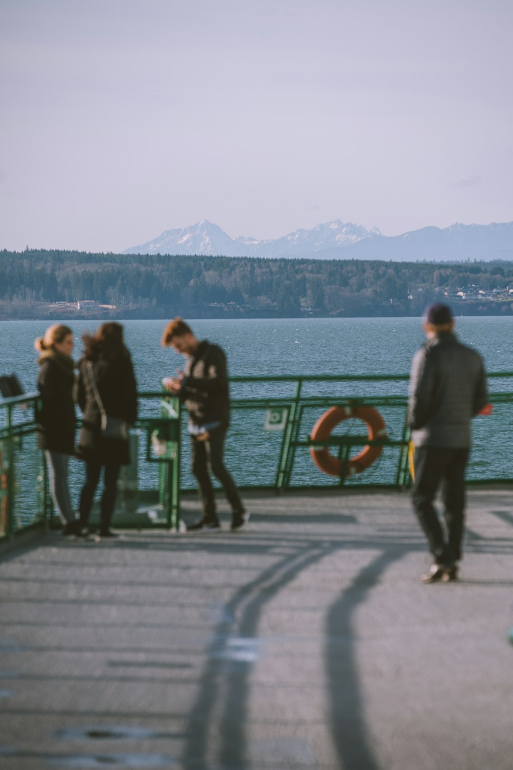 people standing on gray concrete floor near body of water during daytime