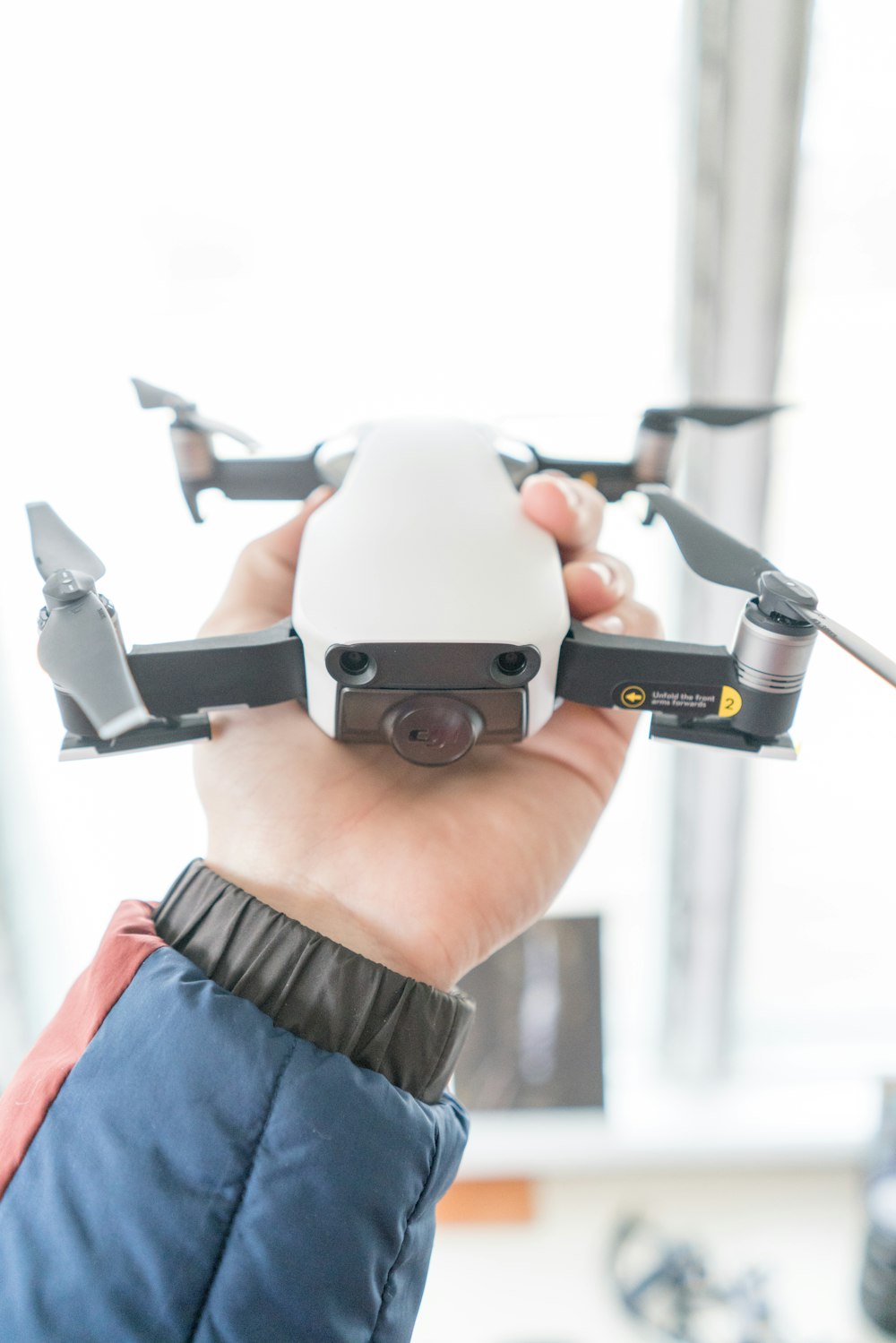 person in brown shirt holding gray and black drone