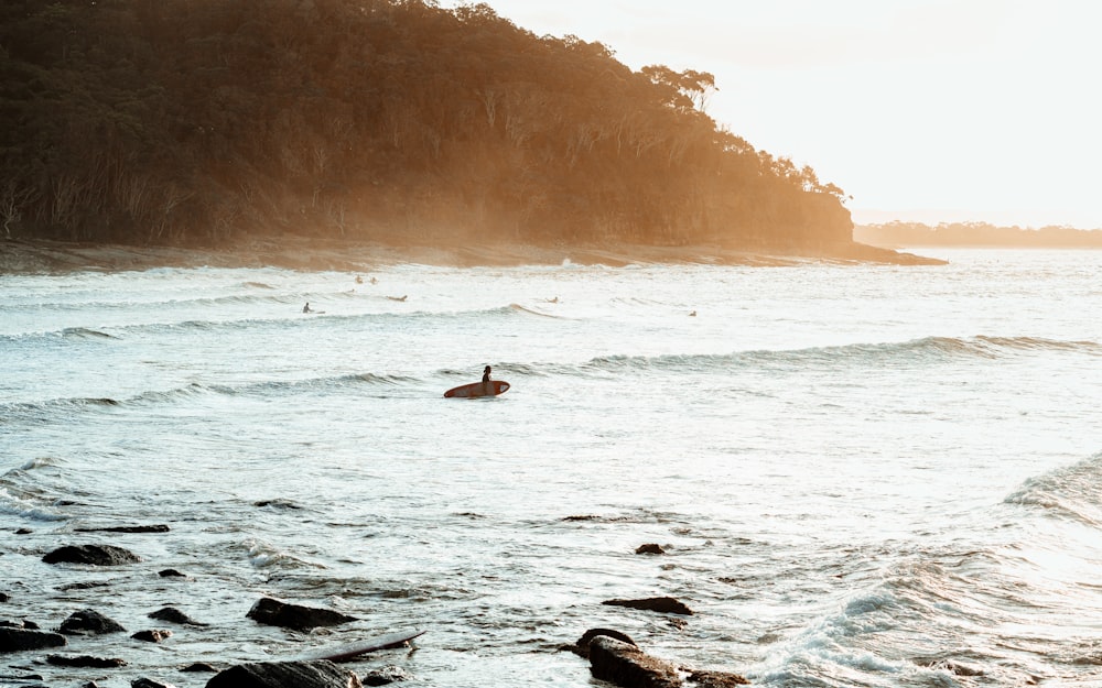 person surfing on sea waves during daytime