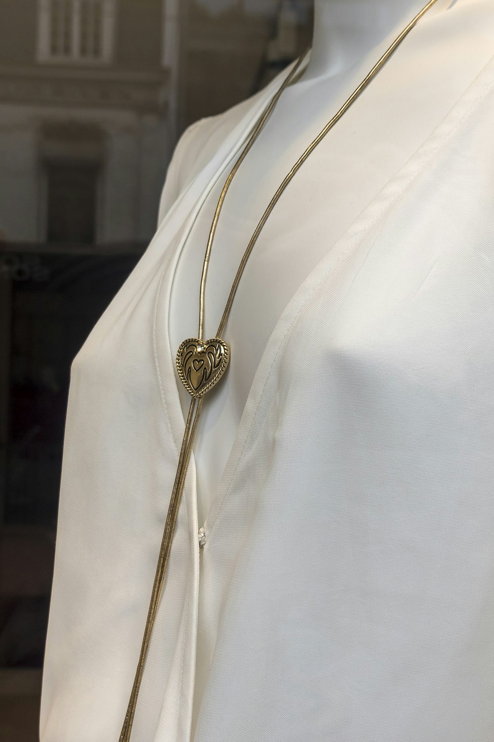 Collier pendentif rond en or sur textile blanc
