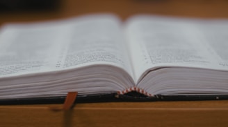 An open book surrounded by colorful bookmarks and stickers on a wooden table.