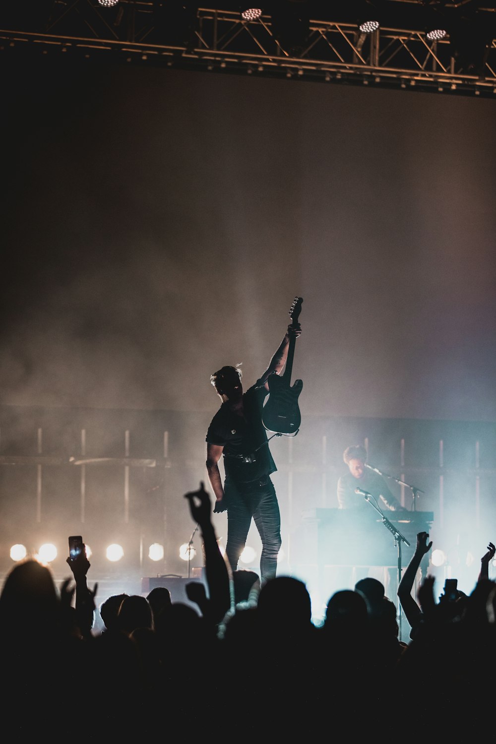 man in black shirt and black pants singing on stage